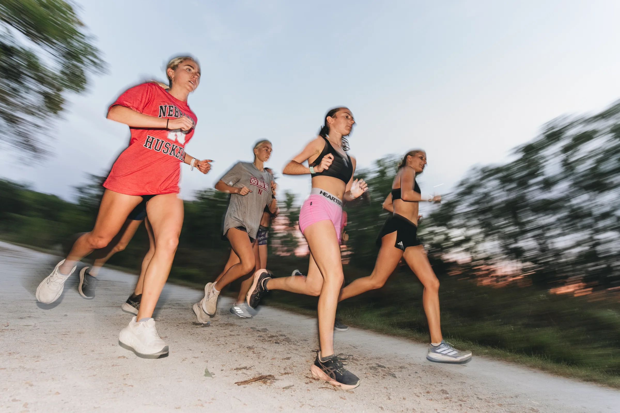 Members of the Nebraska Cornhuskers women's cross country team run along a trail during an early morning training session in Lincoln, Neb.