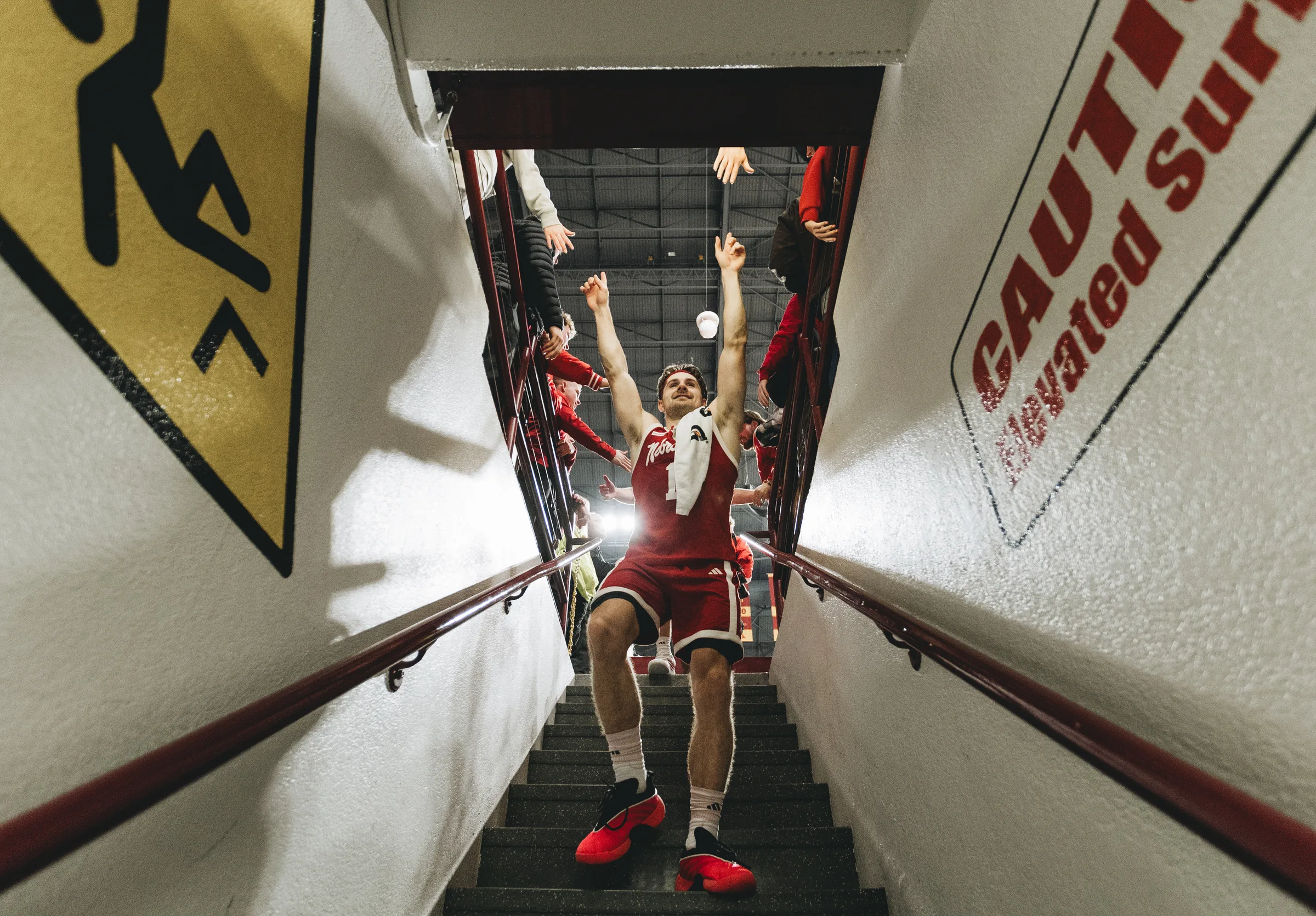 Nebraska guard Sam Hoiberg raises his arms toward fans while descending the tunnel stairs to the locker room at Williams Arena in Minneapolis, Minnesota. Nebraska defeated Minnesota 76-57 on Saturday, Jan. 24, 2026, improving to 20-0 on the season and 9-0 in Big Ten Conference play.