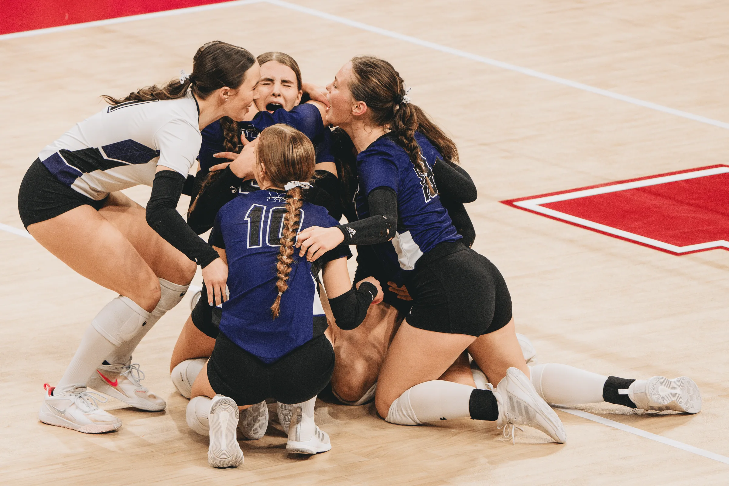 Members of the Minden Whippets volleyball team pile onto the court in celebration after winning the NSAA Class C-1 state championship at the Bob Devaney Sports Center in Lincoln, Neb. Top-seeded Minden defeated Wahoo in four sets on Nov. 9, 2024, to claim its second consecutive state title and finish the season 37-1.