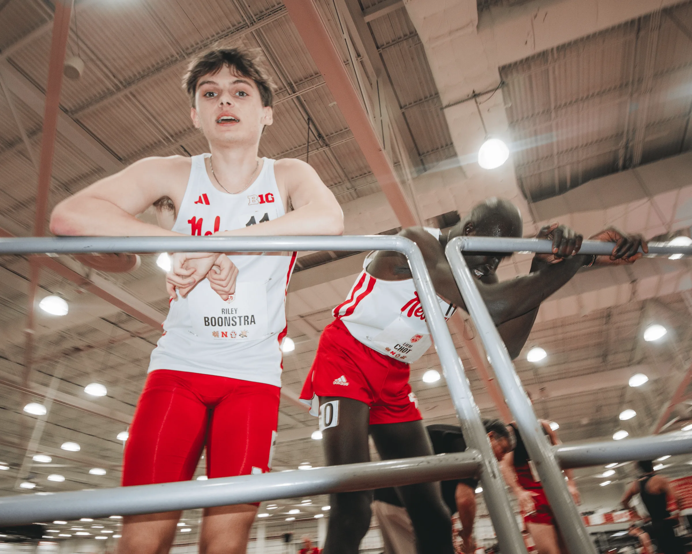 Nebraska freshman distance runner Riley Boonstra leans against a railing and catches his breath after finishing in the 1,600-meter race.