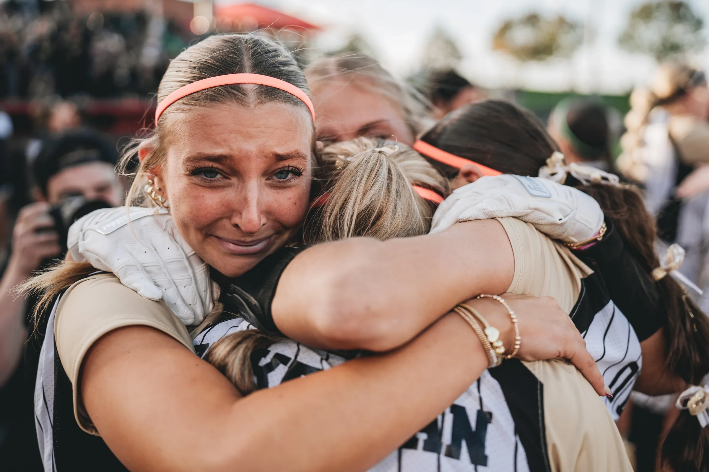 A softball player weeps in the arms of teammates on the field at Bowlin Stadium in Lincoln, Nebraska on Monday, Oct. 20, 2025.
