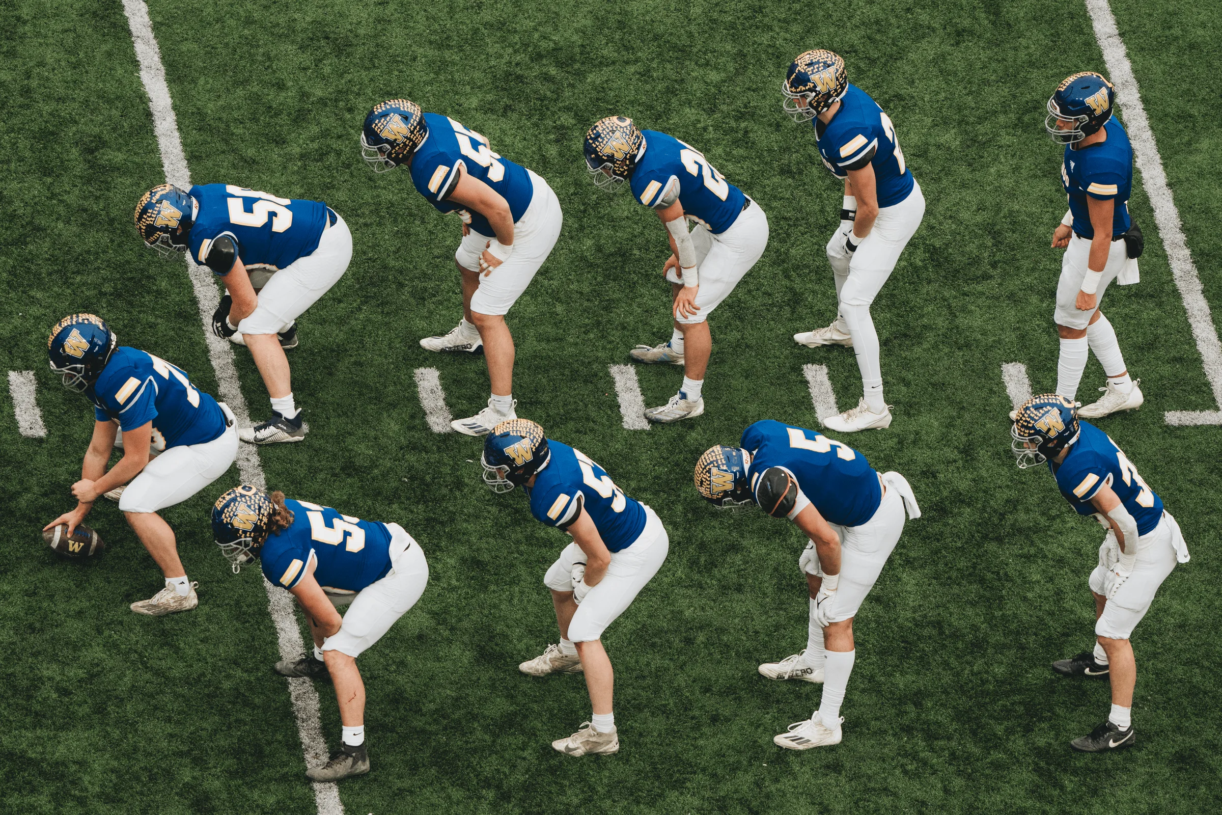 Wahoo Warriors players line up in a V formation at the line of scrimmage during the NSAA Class C-1 State Championship game at Memorial Stadium in Lincoln, Neb. Wahoo's dominant defense recorded a state-championship-record seven interceptions in a 47-7 rout of Central City on Nov. 26, 2024, securing the program's second state football title.